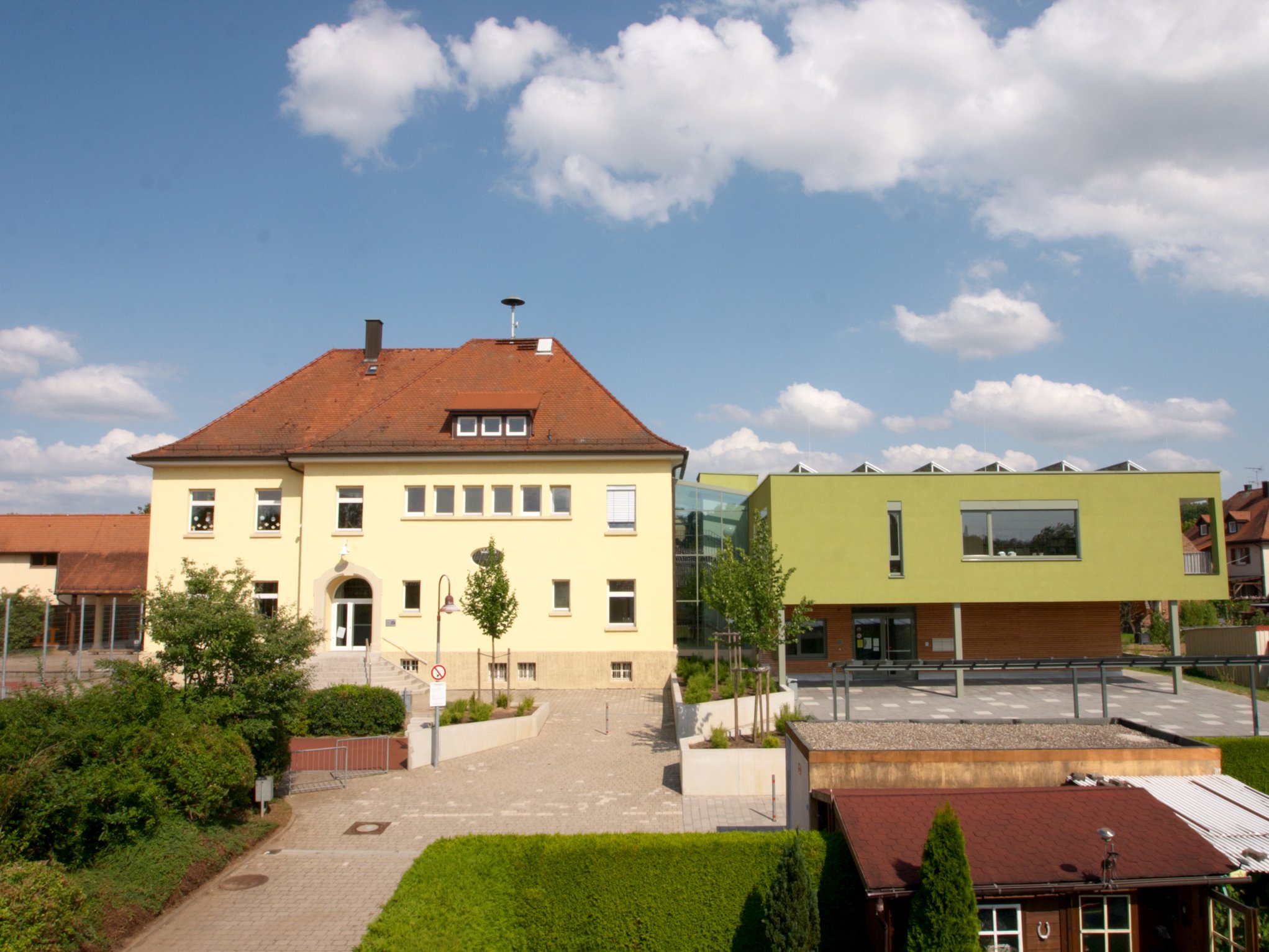 Sie geben Bildung ein Zuhause: das historische Grundschulgebäude aus dem Jahr 1910 (links) und das 2011 eingeweihte Multifunktionsgebäude. (Foto: Petra Harris)